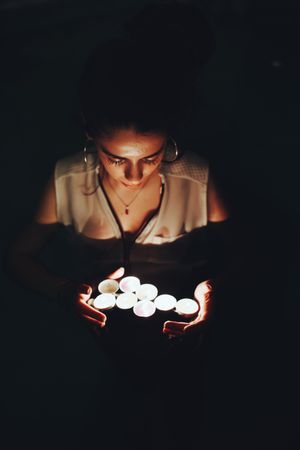 Woman swimming in pool with candles