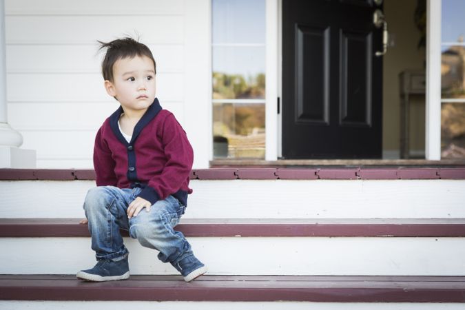 Curious Boy Sitting on Front Porch Steps
