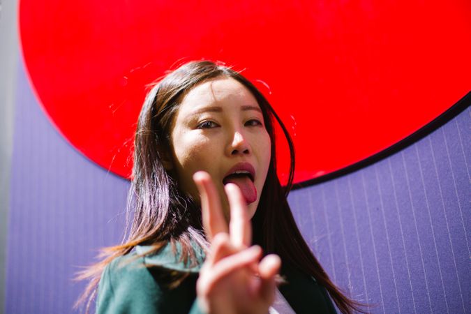 Asian woman showing tongue and V sign