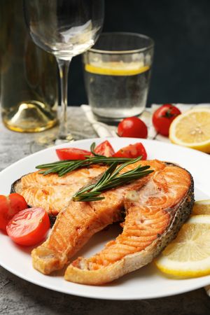 Composition with tasty grilled salmon on gray background, close up