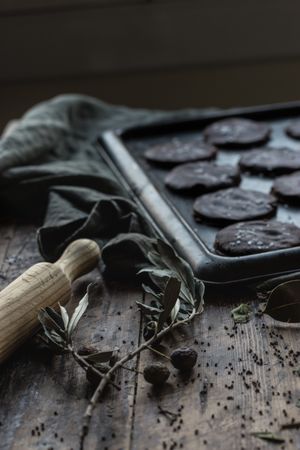 Olive twig and rolling pin near chocolate biscuits