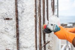 Construction worker with angle grinder polishing rods