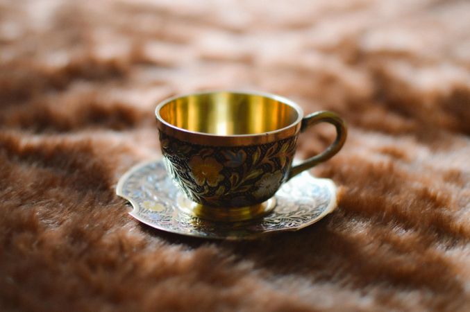Golden cup and saucer on textile