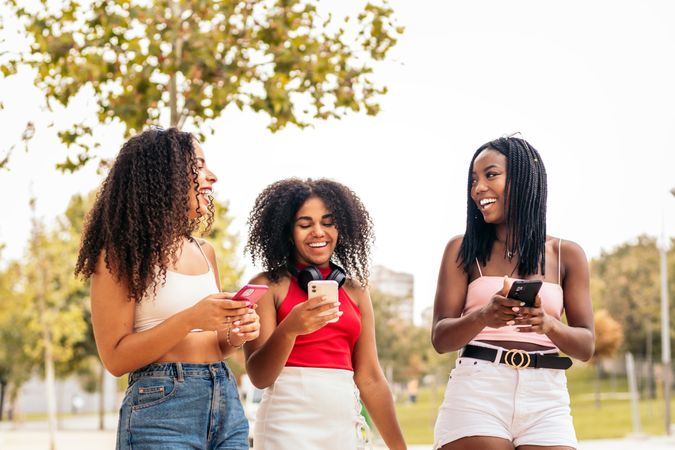 Black Female Friends Enjoying Summer Together and using smartphone