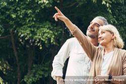 Woman pointing hand to sky and talking with a man 5nvj85