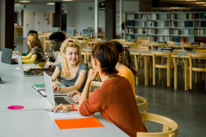 Group of multiethnic students sitting in library