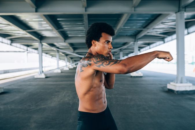 Black male athlete doing boxing training in underpass