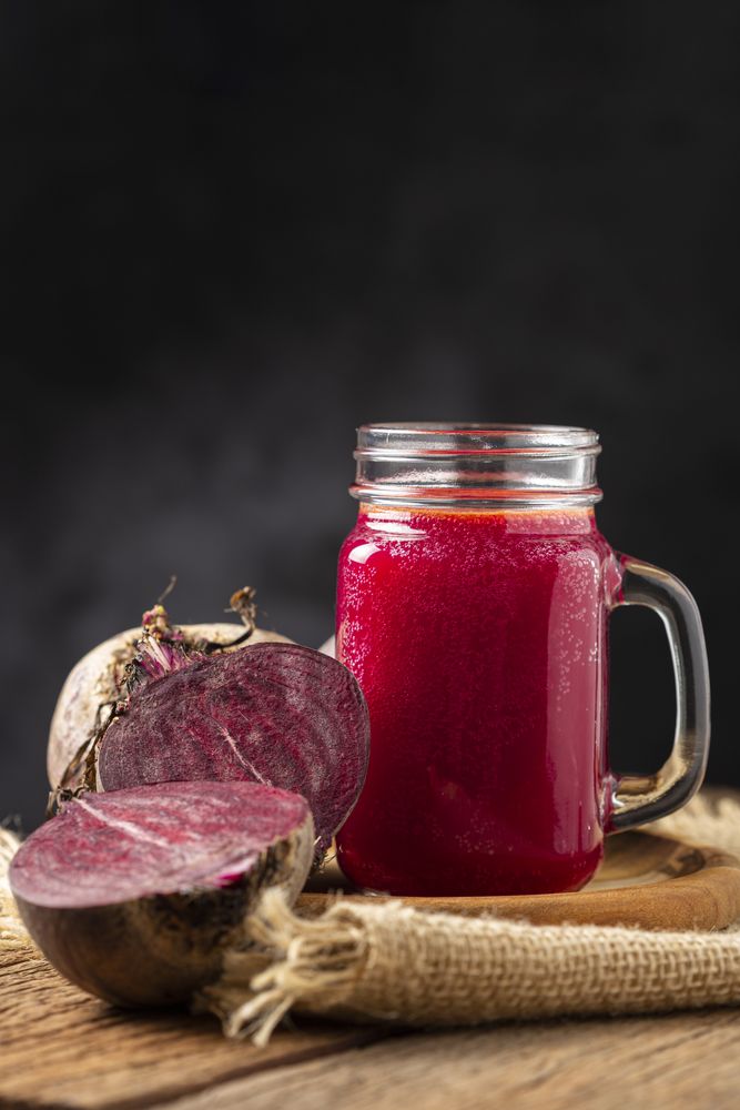 Red beet juice in a glass cup on the wooden table.