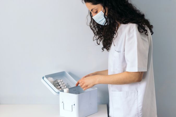 nurse taking medicine from medicine cabinet