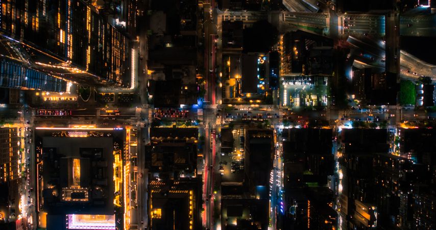 Cinematic Helicopter Night Shot Moving Diagonally Over New York City Avenue Grid System. Top Down Aerial Photo of Congested Streets, Roads, Cars, Nightlife and Tall Modern Skyscrapers