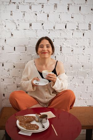 Peaceful woman drinking coffee while resting at home