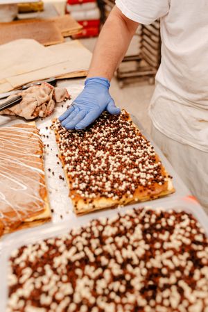 Anonymous baker spreading sprinkles on pastry