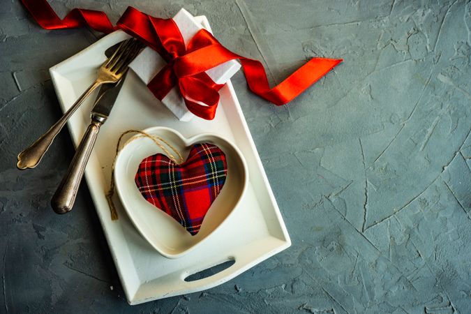 St. Valentine day table setting with heart plate and tartan decoration