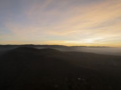 Golden Horizon Over Misty Hills and Scattered Homes.