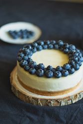 Homemade blueberry cheesecake on wood pedestal
