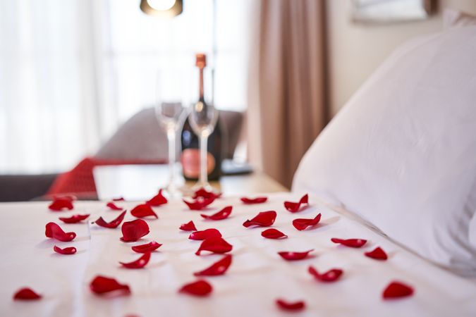 Bed with bedclothes covered with rose petals