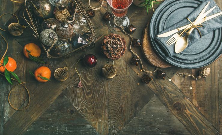 Top view of table setting with glass of rose Champagne, pinecone, and candle, with copy space