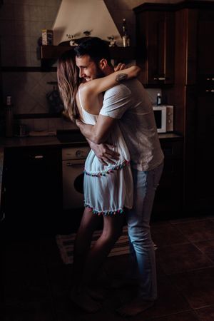 Happy couple embracing in kitchen