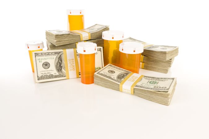 Medicine Bottles and Stacks of Hundreds of Dollars