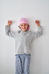Happy boy smiling and showing biceps during rehabilitation