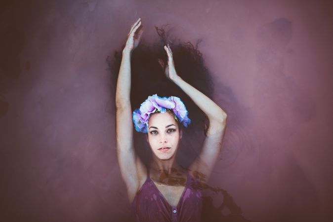 Woman with wreath lying in water