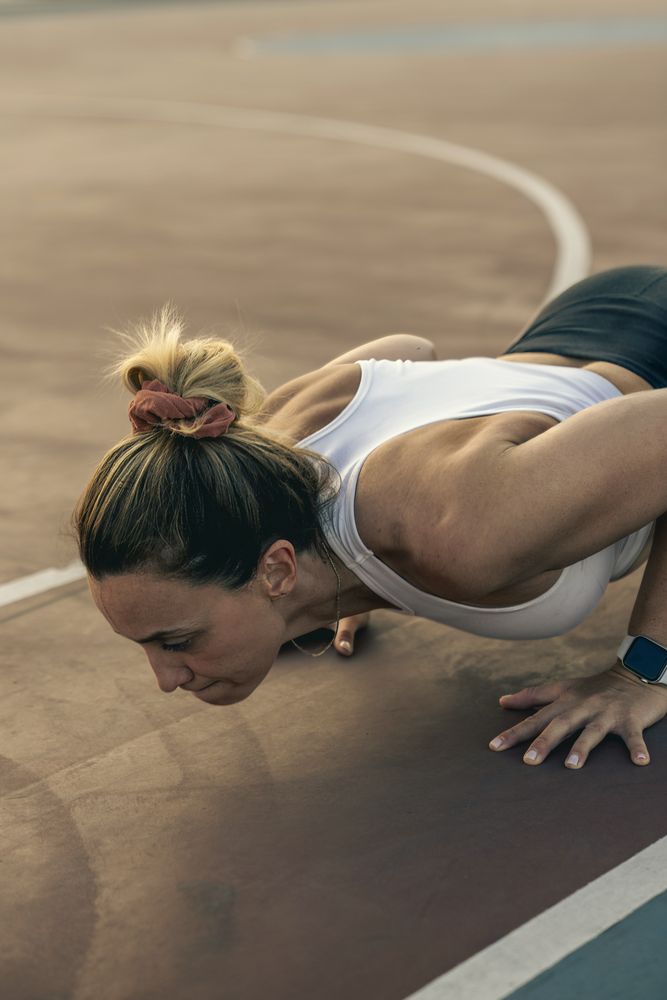 Determined woman doing a push-up exercise during an intense outdoor workout