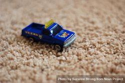 Small toy truck on beige carpet 567Ml4