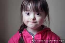 Portrait of a young girl with Down syndrome making a baffled face 5o1Xmb