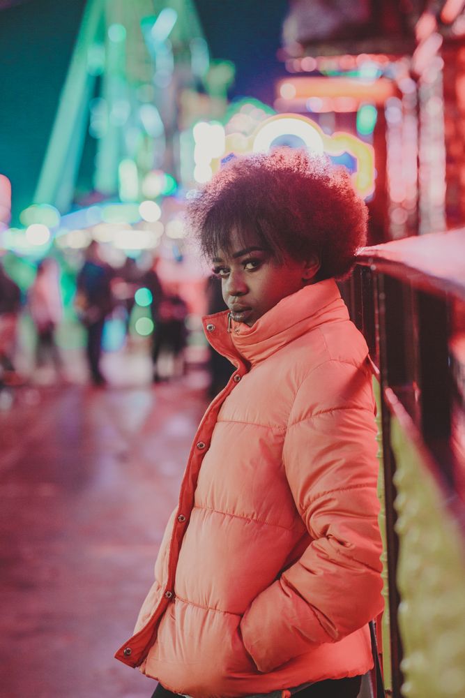 Black female standing near attraction in amusement park