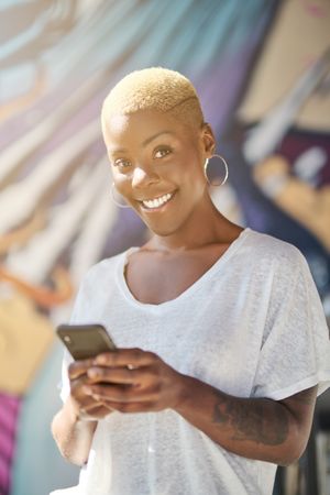 Smiling Black woman using smartphone