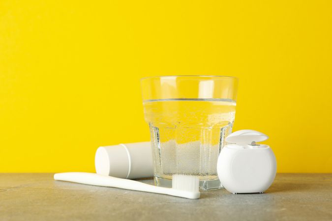 Tools for dental care on yellow background, space for text