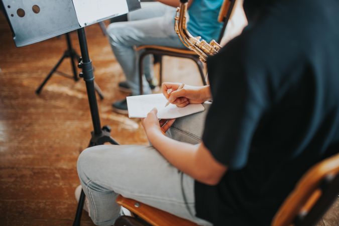 Cropped shot of student writing down notes in band practice