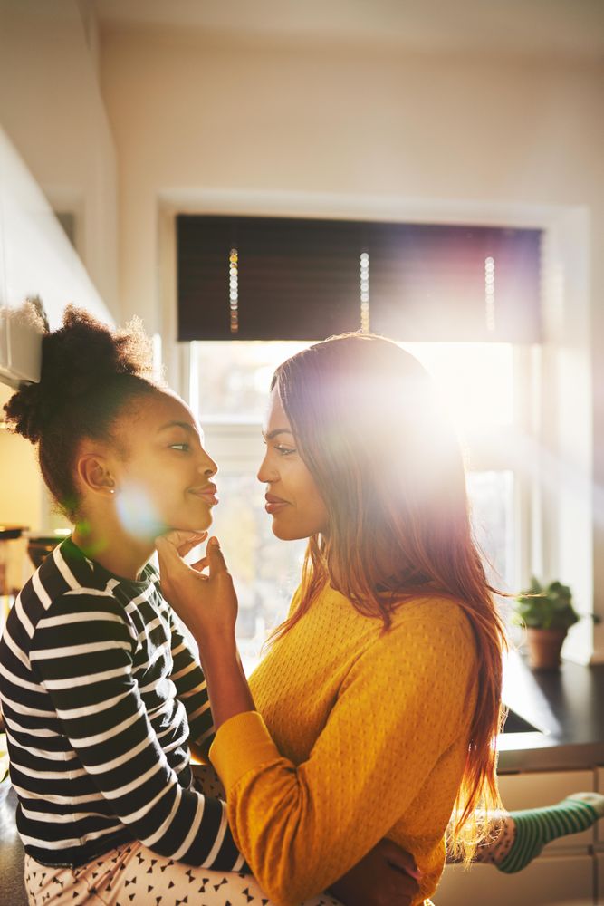 Mother holds her daughter’s chin in bright kitchen