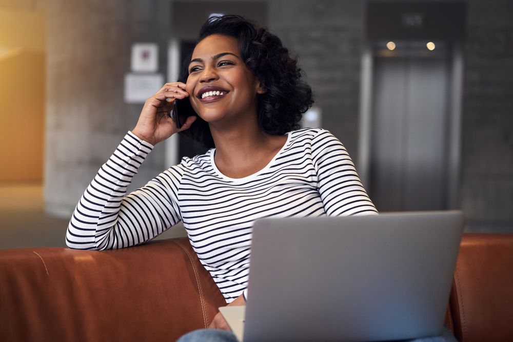 Woman smiling on phone call in atrium of building