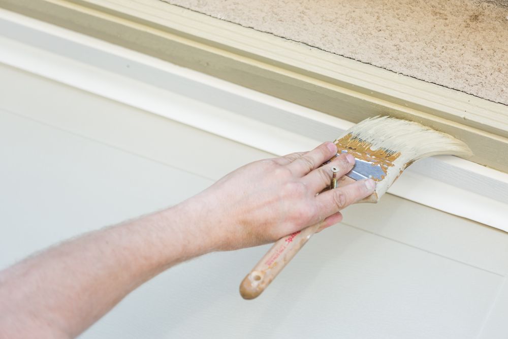 Professional Painter Cutting In With Brush to Paint Garage Door Frame