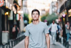 Confident Asian man walking along city street