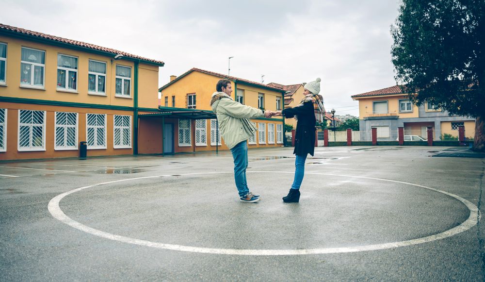 Couple standing together holding hands in circle in sports court