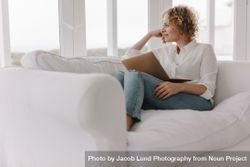 Woman sitting on couch at home with a laptop 5aXOPv