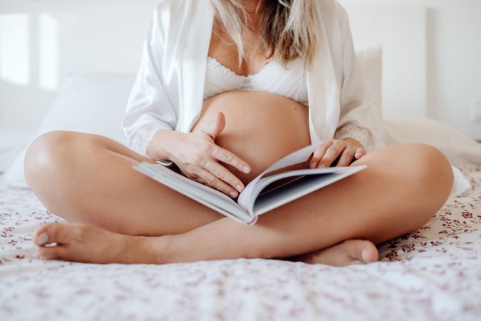 Pregnant woman reading book at home