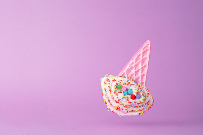 Cute falling ice cream cone toy on purple background