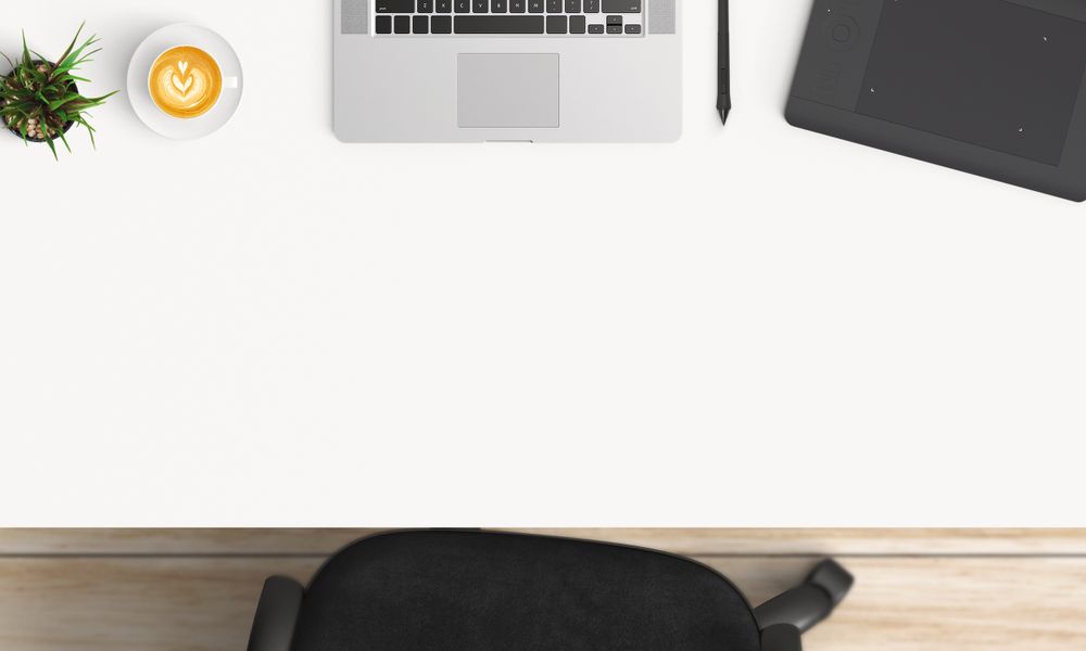 Modern workplace with laptop, coffee cup and notebook copy space on table background. Top view. Flat lay style.