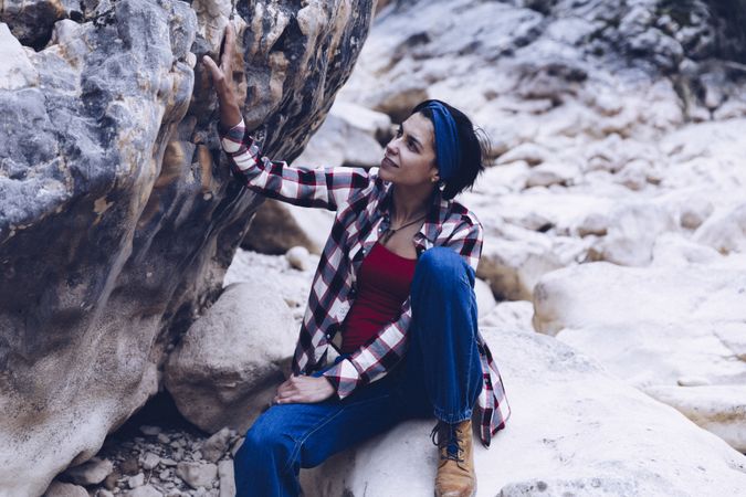Positive woman sitting on stone