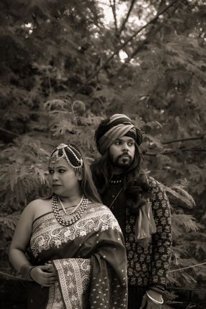 Grayscale of Indian couple standing beside tree outdoor