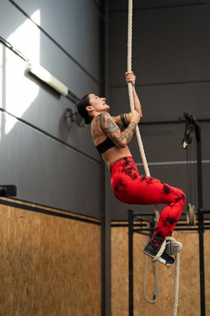 Athletic woman exercising with a rope in a gym
