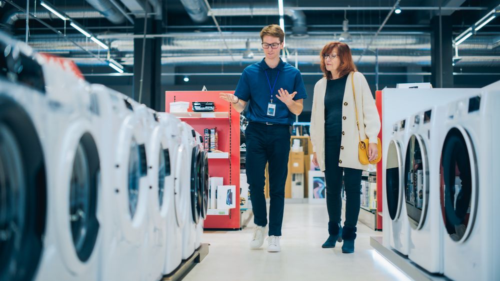 Customer Explores Laundry Appliance Options. Shopper in a Modern Retail Shop