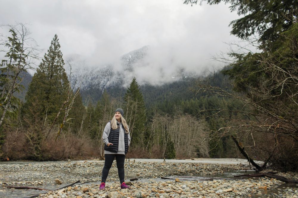 Woman in the mountains standing near a stream