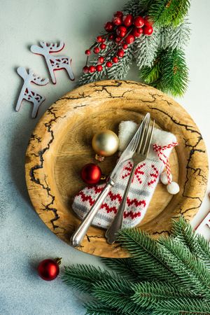 Top view of rustic plate with baubles, and pine branches