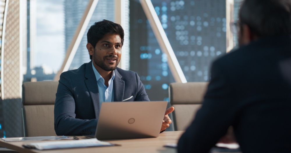 Business Adviser Using Laptop Computer, Talking with a Client in Conference Room