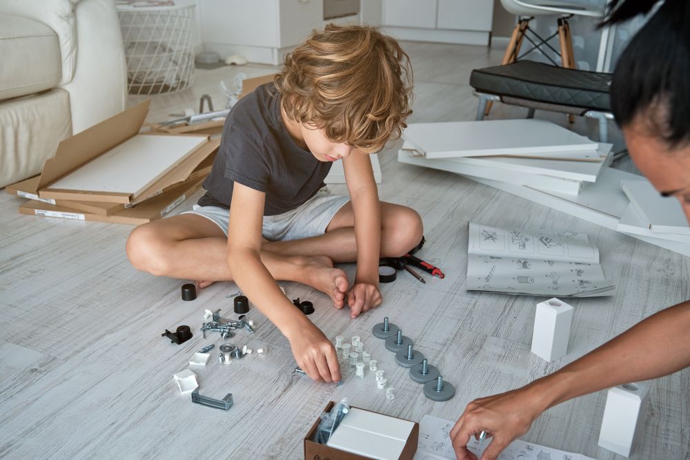 Crop mother and son assembling furniture at home