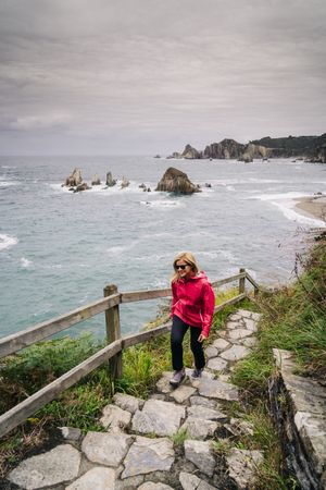 Woman climbing stairs that come from the seashore